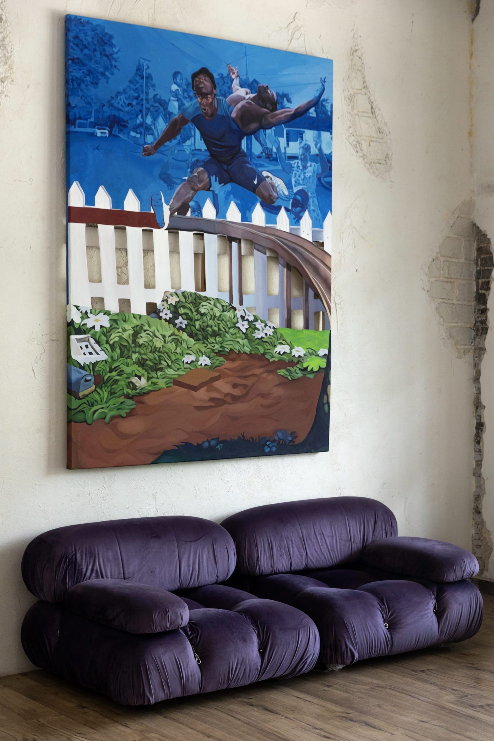 a purple loveseat with a figurative painting hanging on the wall above