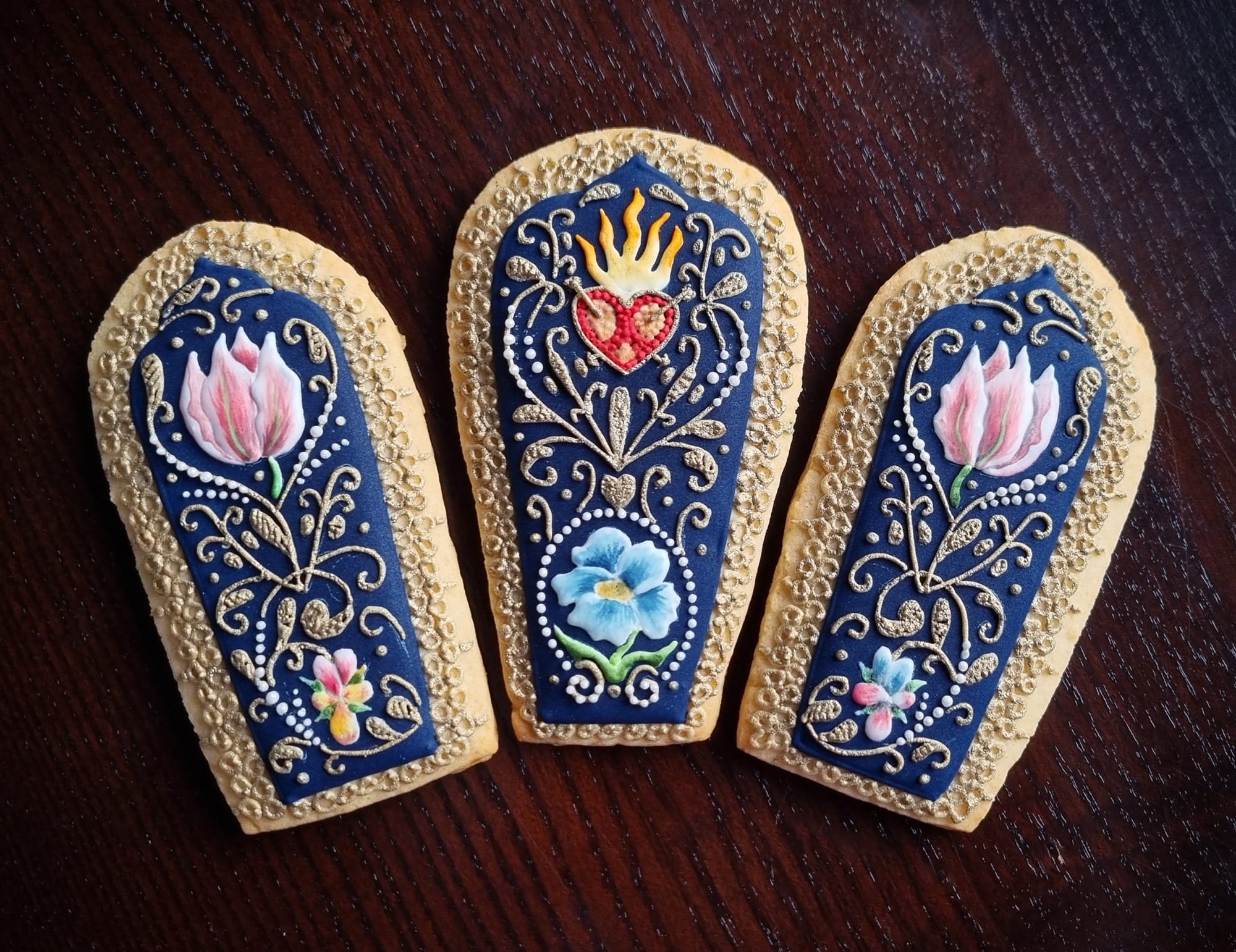 three cookies with blue icing and flowers