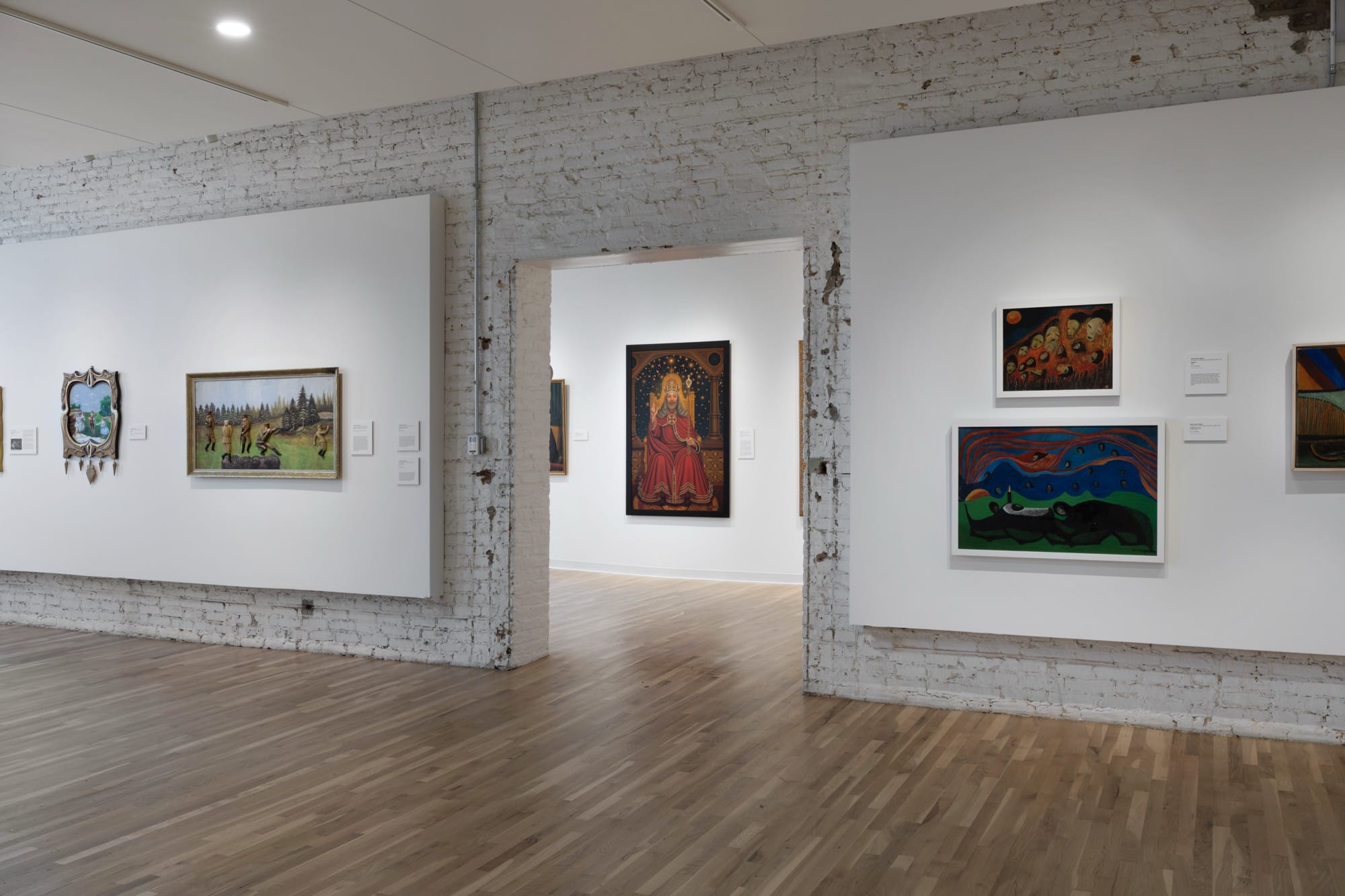 an installation view of paintings on a wall
