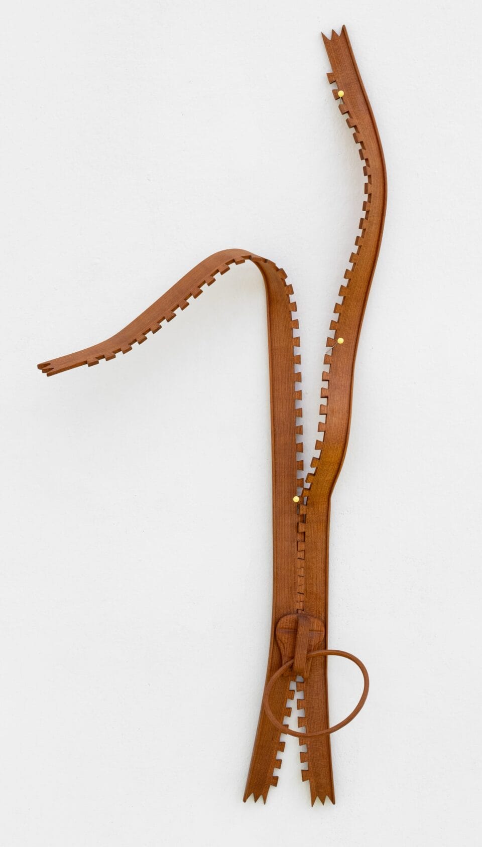 an abstract, wooden wall sculpture resembling a zipper