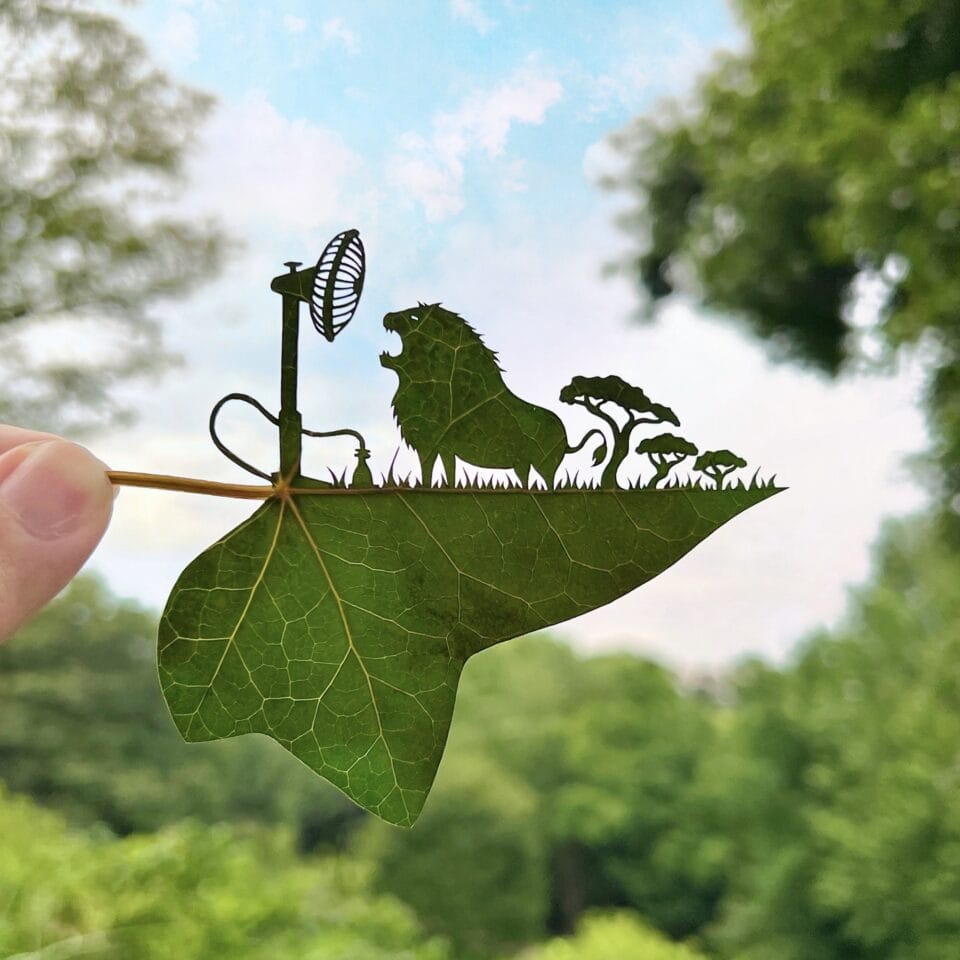 a cut leaf artwork of a lion roaring into a fan