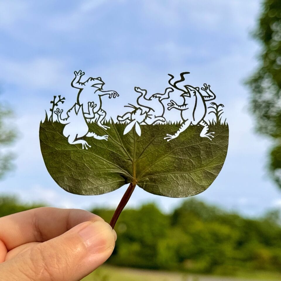 a cut leaf artwork of dancing animals
