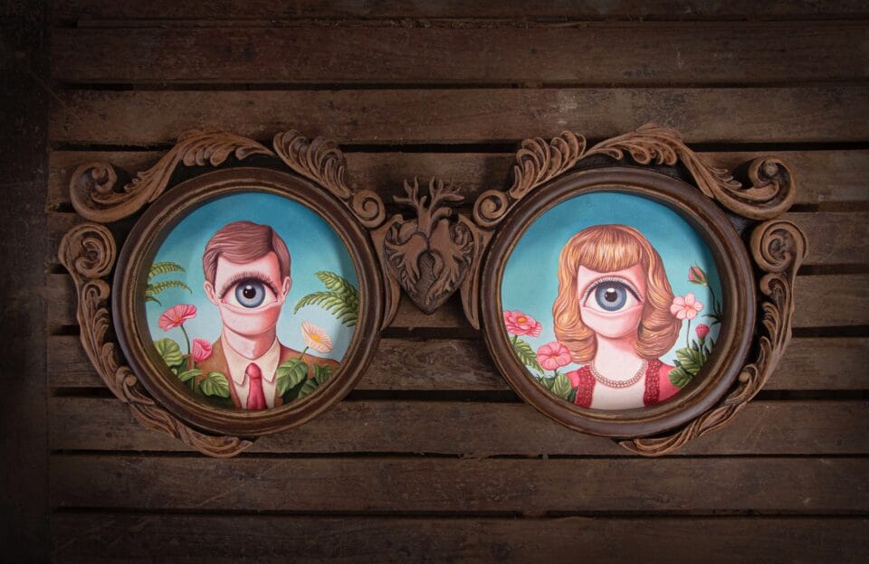 a surreal pair of round portraits of a man and a woman, both with one giant eyeball on their face